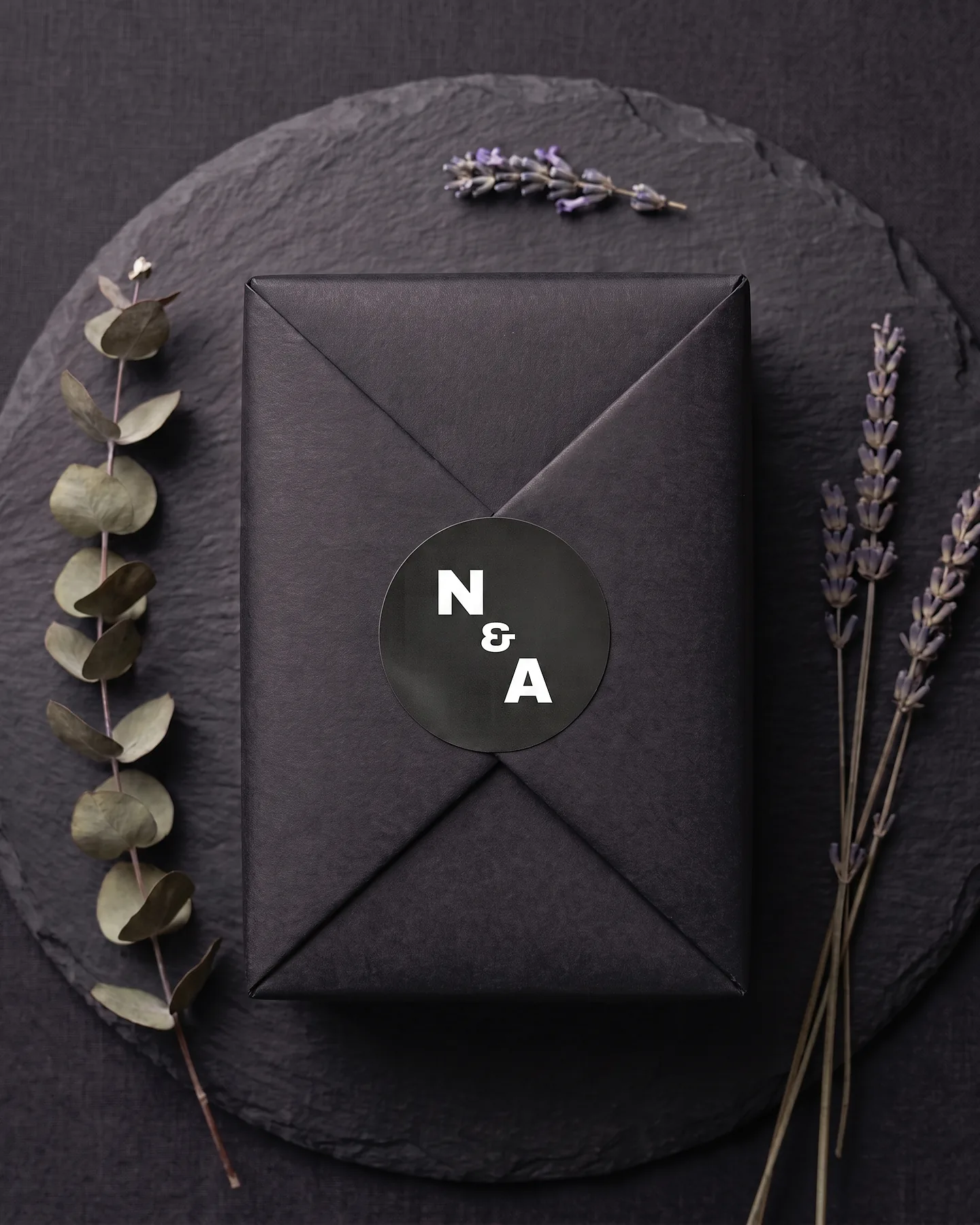 A Notes & Archives parcel wrapped in black tissue and sealed with the studio's monogram.